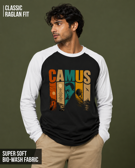 A man wearing a black and white raglan long-sleeve t-shirt with a retro-style graphic of the name 'CAMUS' in warm colors and a portrait of Albert Camus. The image has text overlays highlighting 'CLASSIC RAGLAN FIT' and 'SUPER SOFT BIO-WASH FABRIC'.
